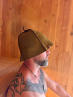 person wearing a green sauna hat wool