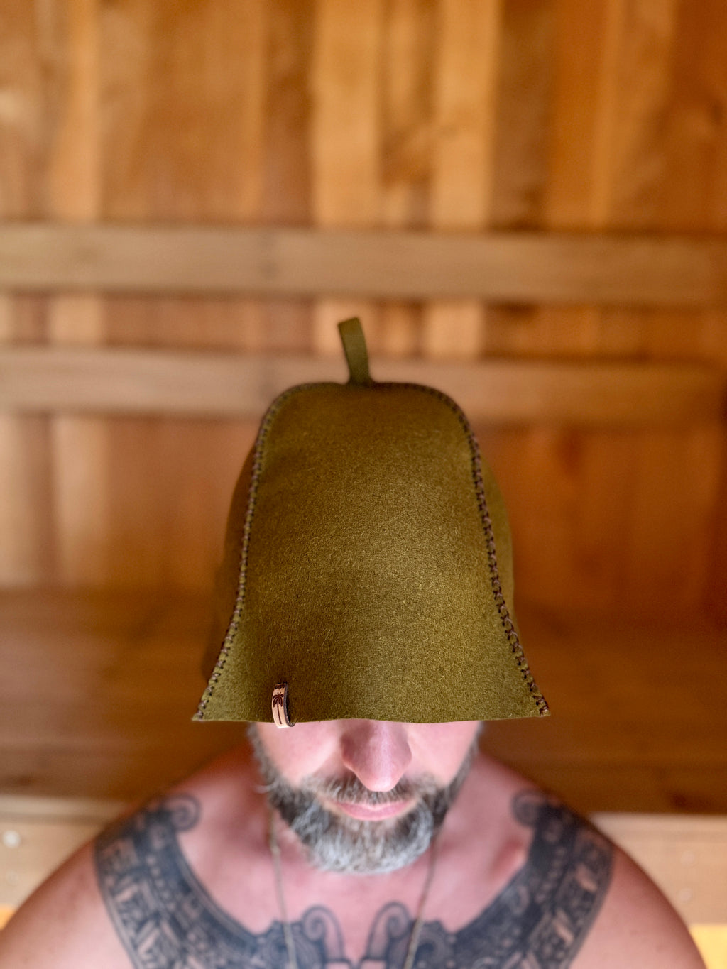 person wearing a green wool sauna hat in wooden sauna