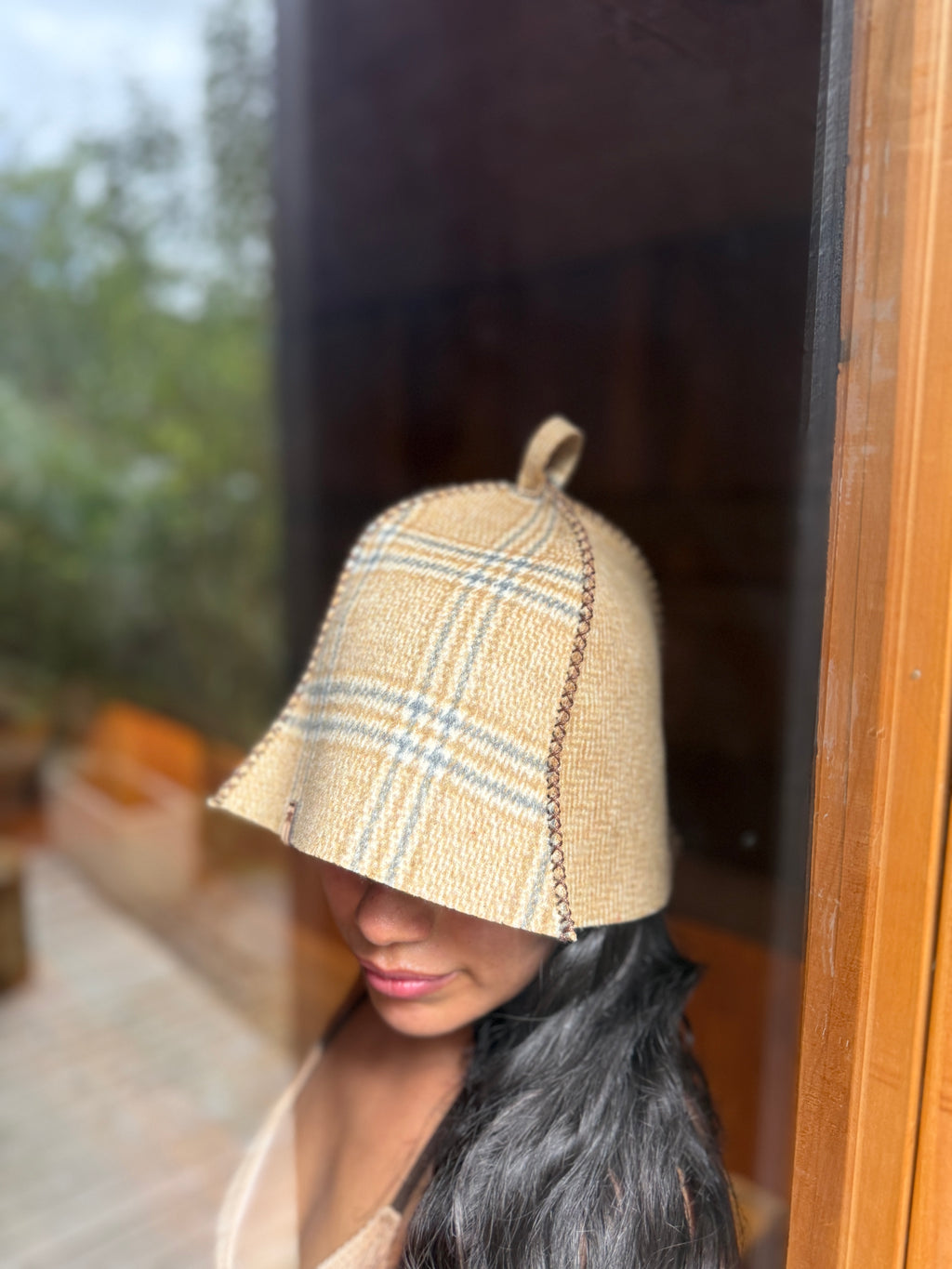 person wearing a beige plaid sauna hat outdoor