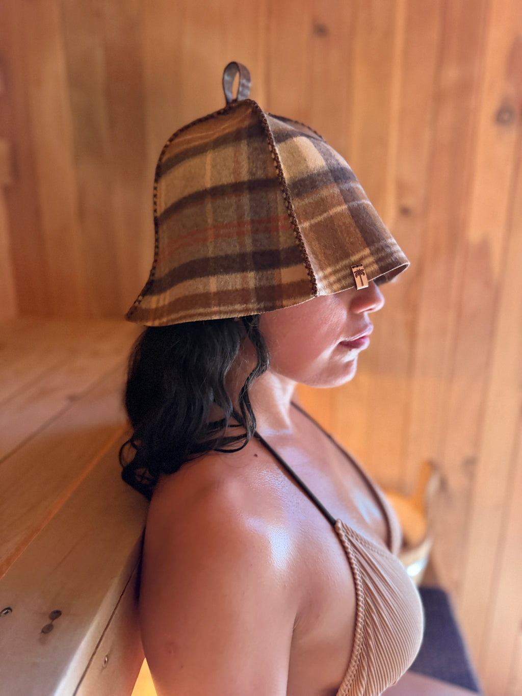 person wearing brown wool sauna hat in sauna