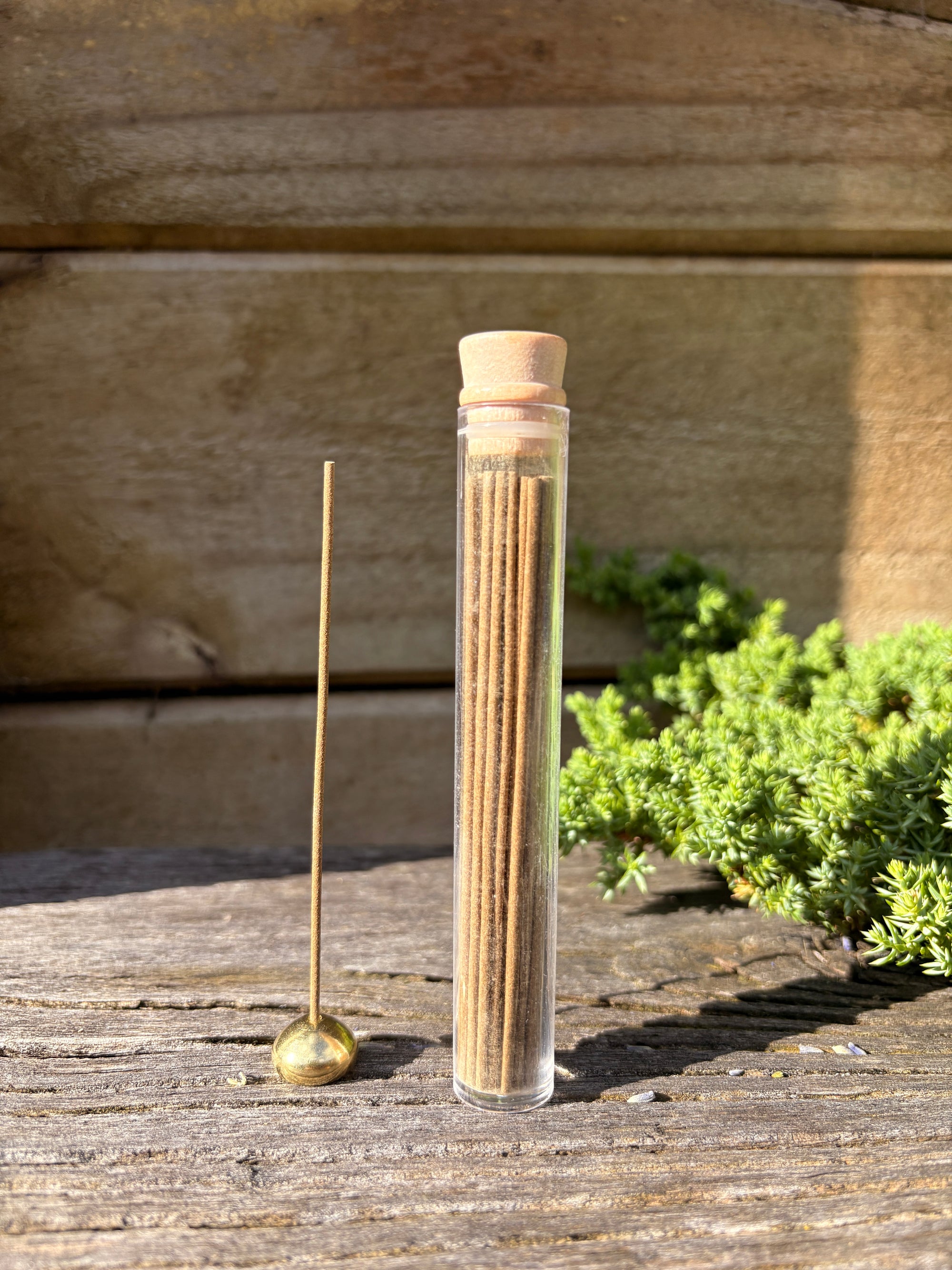 cesar incense with a golden ball holder on a wooden surface