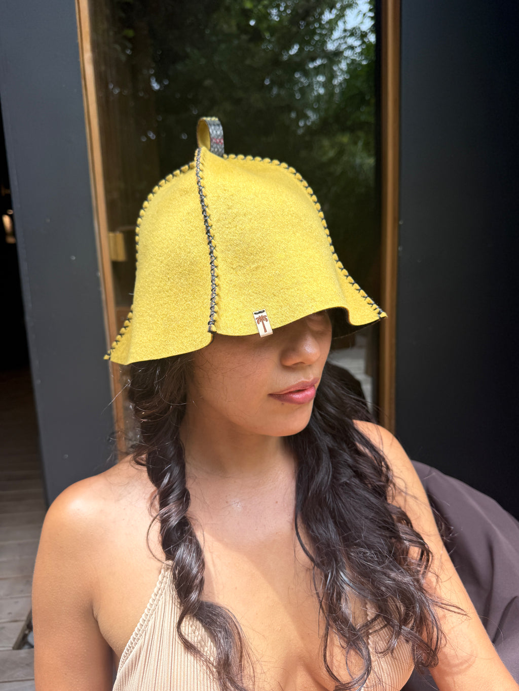person wearing yellow wool sauna hat in sauna