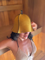 woman wearing yellow wool sauna hat in a sauna